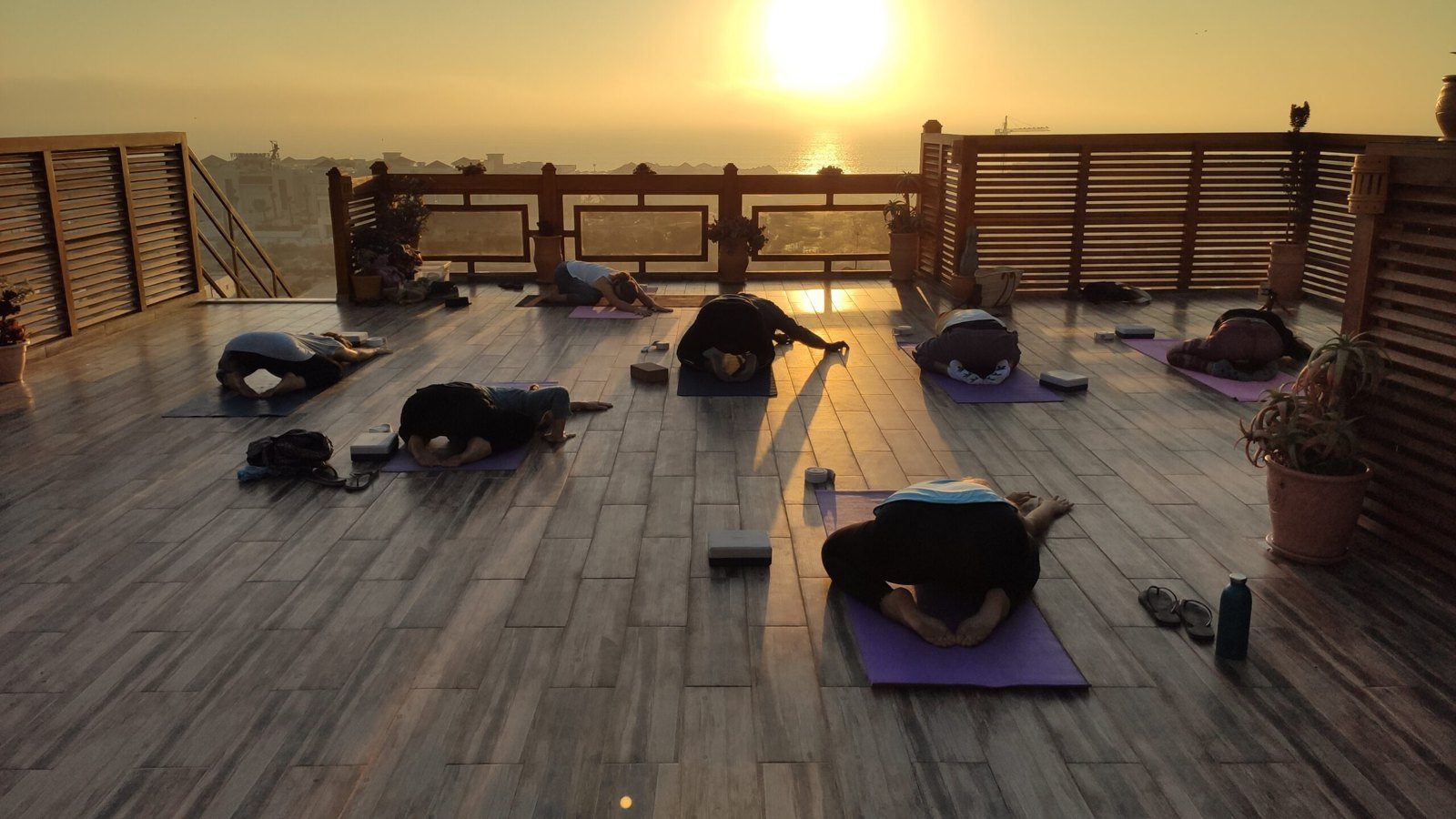 Yoga on the rooftop terrace as the sun sets over the ocean